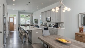 A modern kitchen with grey cabinets, stainless steel appliances, and a central island with bar stools. - Skyline Retreat  Minutes To Downtown + Free Parking (Nashville)