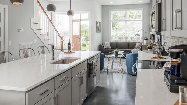 A modern kitchen with a large island, stainless steel appliances, and a dining area with a glass table and blue chairs. - Skyline Retreat  Minutes To Downtown + Free Parking (Nashville)