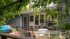 A deck with outdoor furniture, a grill, and a covered patio area.