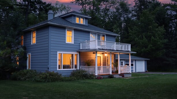 A two-story house with a balcony, a covered porch, and a garage.