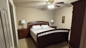 A bedroom with a bed, nightstands, a ceiling fan, and a door. - 1109 S. Boston Pl 3 bedroom, 2 bath house (Russellville)