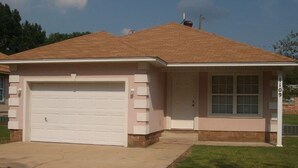 A single-story house with a garage, a front door, and a small porch. - 1109 S. Boston Pl 3 bedroom, 2 bath house (Russellville)