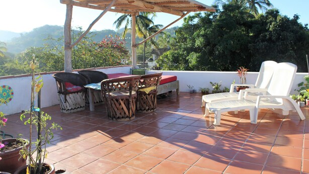 A terrace with a wooden pergola, a table with chairs, and potted plants. - Casita Tortuga, spacious 1BR1BA, roof terrace w view, walking dist to beach&town (Sayulita)