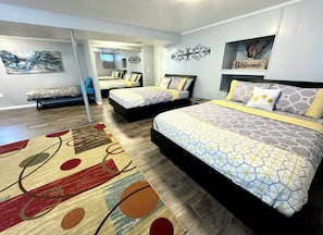 A modern bedroom with two beds, a large mirror, and a welcome sign.