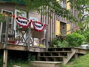A rustic wooden deck with a staircase leading to a house.