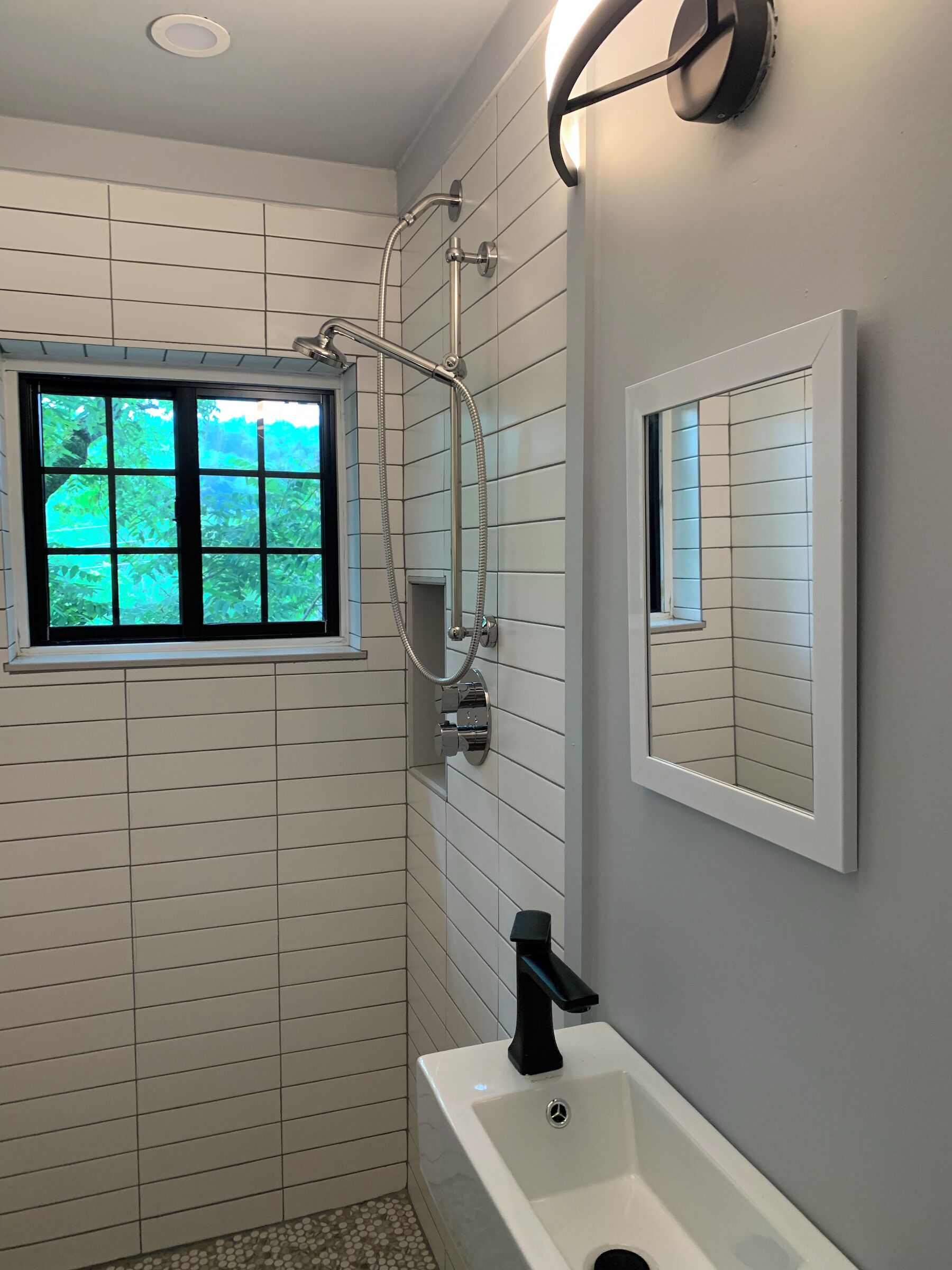 Upstairs  bathroom with window, shower and beautiful tiled walls. 