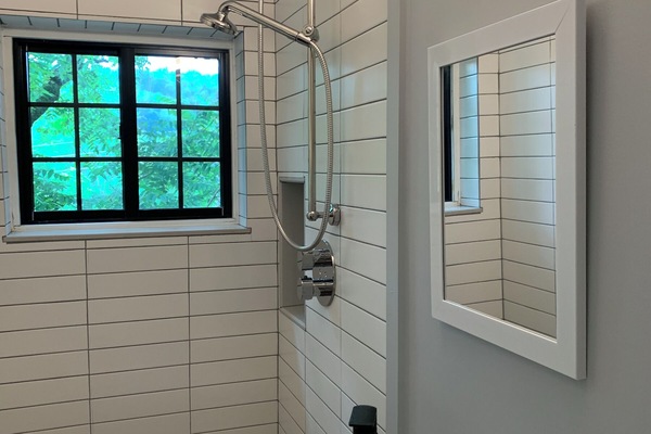 Upstairs bathroom with window, shower and beautiful tiled walls.
