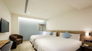 A hotel room with two beds, a desk, a chair, a TV, and a painting on the wall. - Hub Hotel (Taoyuan City)