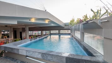 Alberca al aire libre y camastros