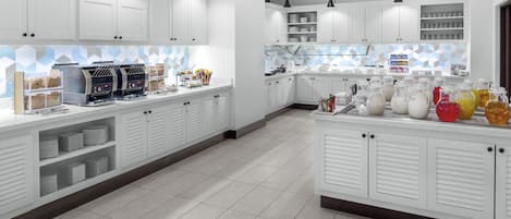 A modern kitchen with white cabinets, a coffee station, and a beverage station.