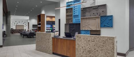A reception area with a counter, seating area, and a wall with various geometric shapes.