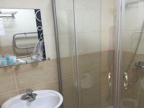 A bathroom with a glass-enclosed shower, a sink, and a mirror above it. - Munkh Khustai Hotel (Ulaanbaatar)