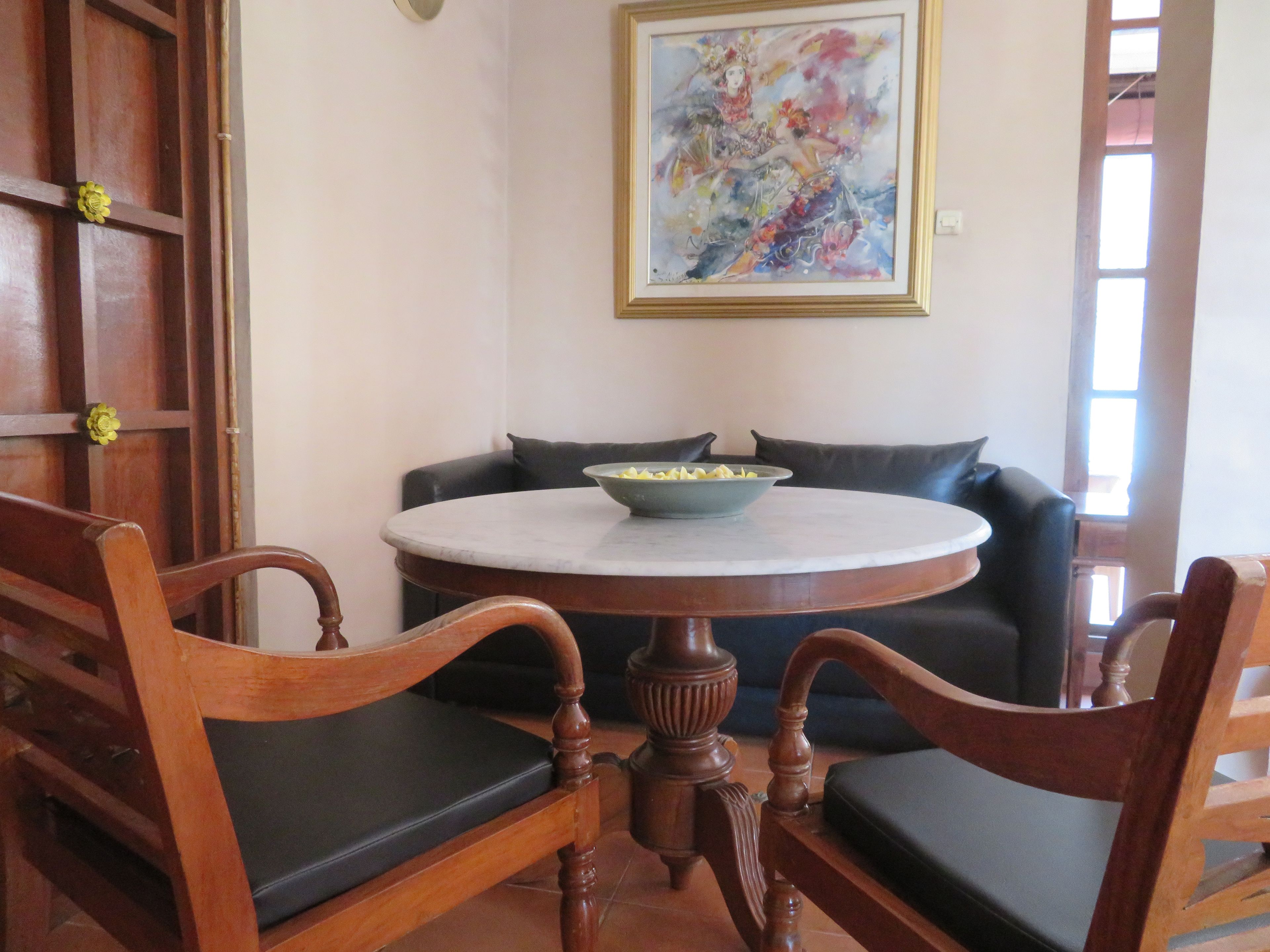 Un comedor con una mesa redonda, sillas de madera y un tazón de comida.