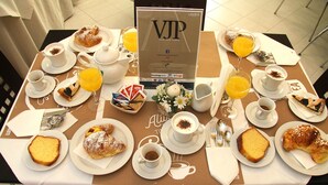 Ein Frühstückstisch mit verschiedenen Backwaren, Kaffee und Saft.