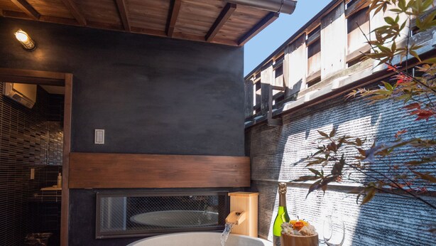 Un área de spa con jacuzzi, detalles de madera y vistas a un edificio.