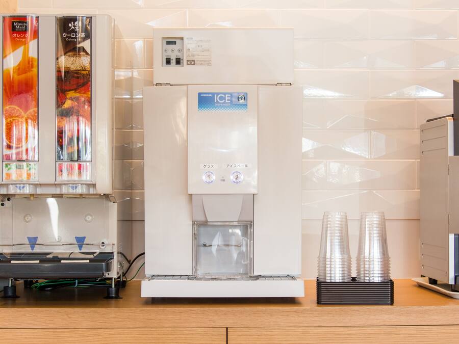 Una macchina distributrice con bevande, un erogatore di ghiaccio e una macchina per il caffè.