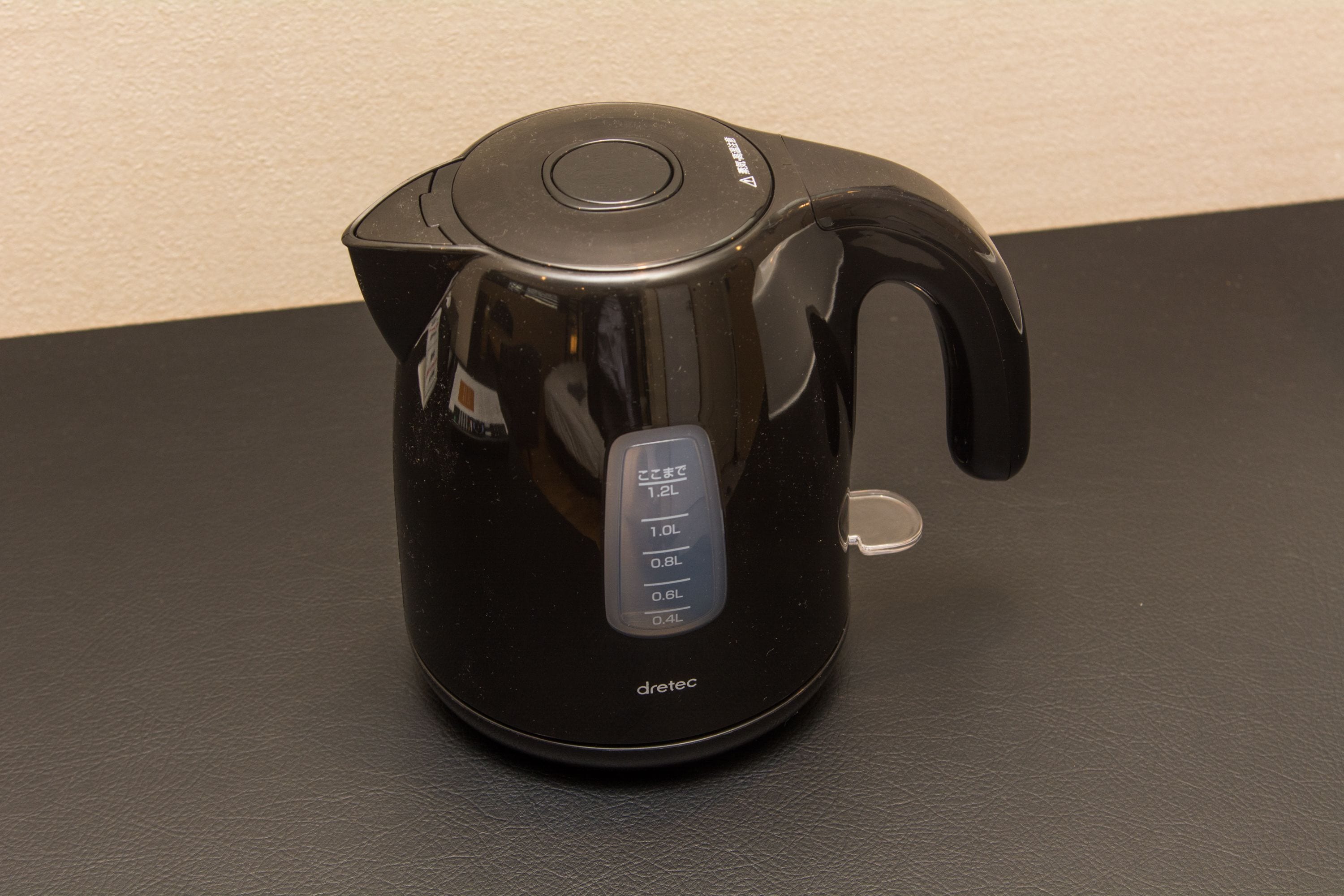 A black electric kettle with a digital display on a black surface.