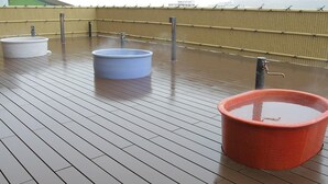 A rooftop deck with three large tubs, a wooden floor, and a yellow fence. - Hagi Royal Intelligent Hotel (Hagi)