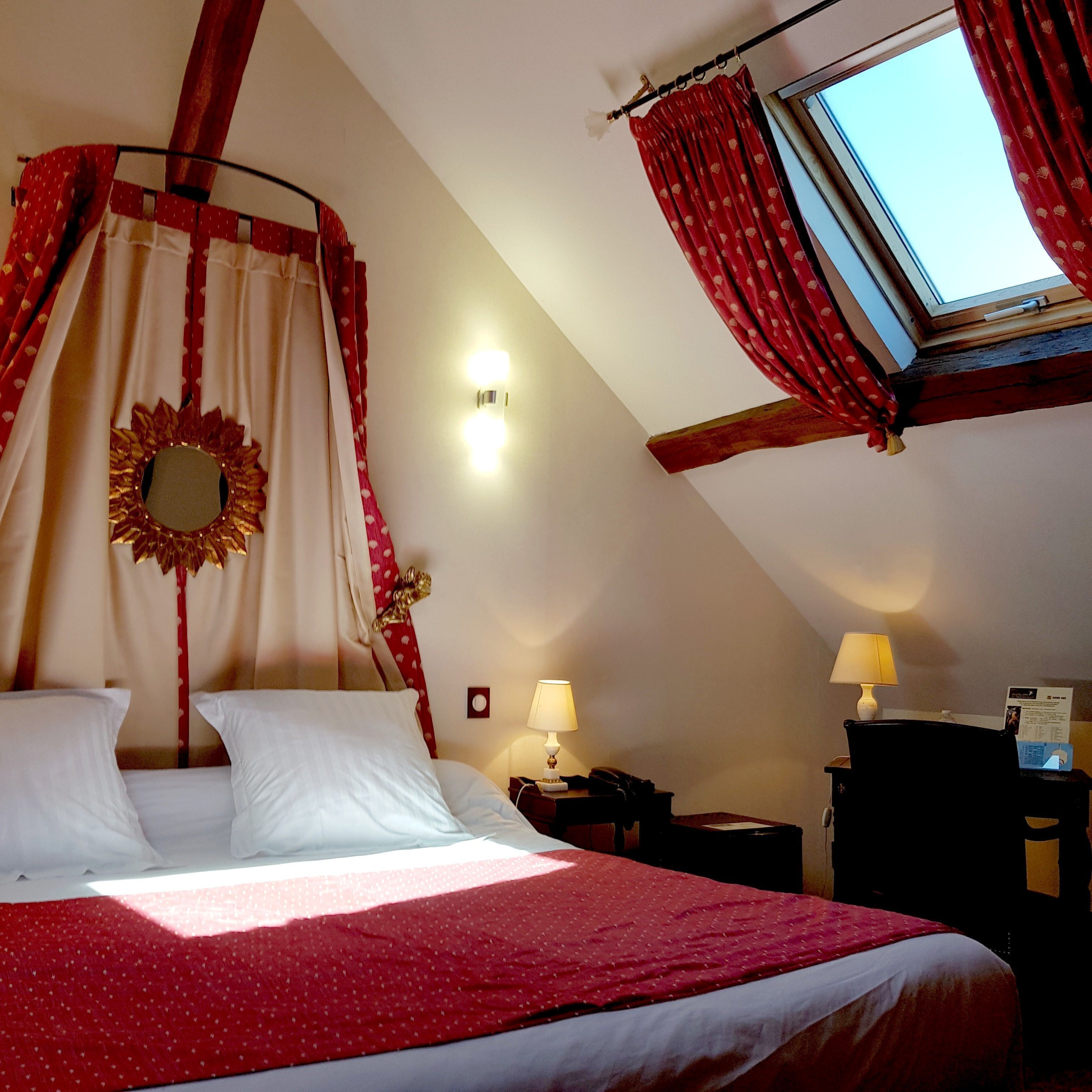 Un dormitorio con cama, dos mesitas de noche, una lámpara y una ventana con cortinas.