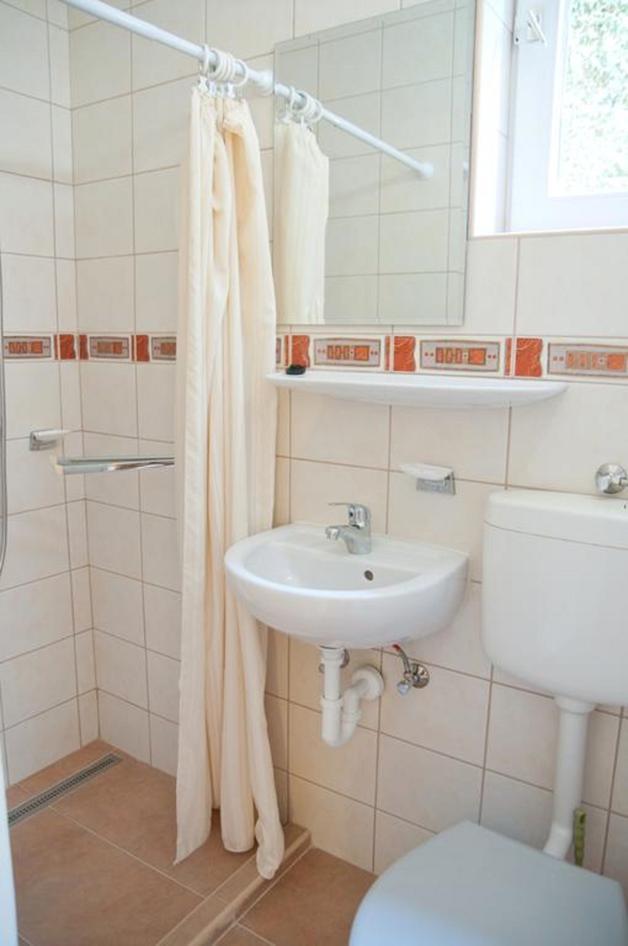 Un baño con ducha, lavamanos e inodoro.