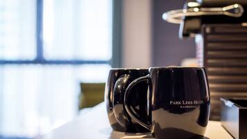 Two black mugs with the text "Park Lees Hotel Kaohsiung" on a table.