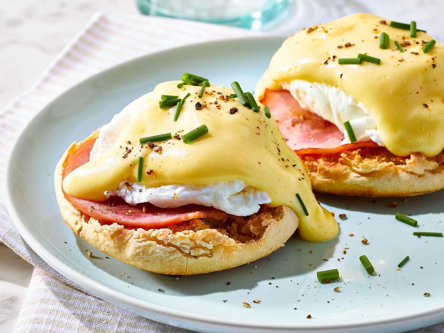 Dos sándwiches huevos benedictinos en un plato.