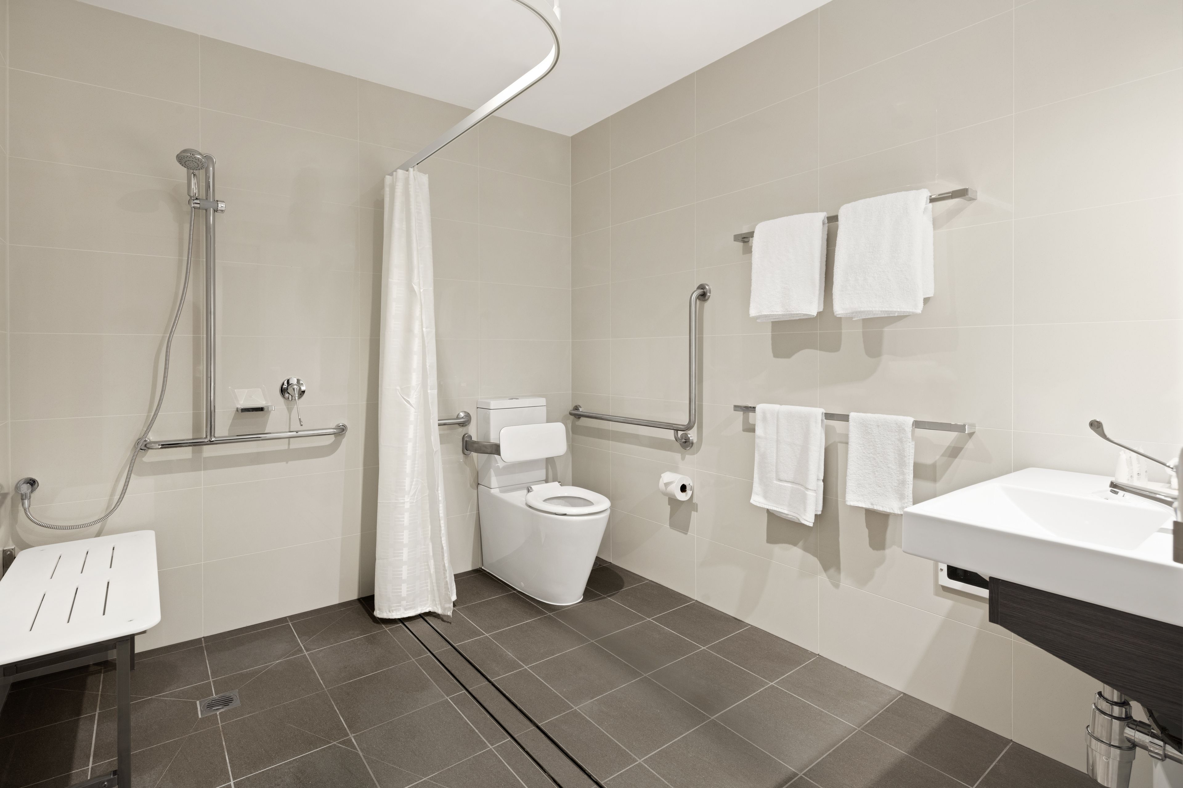 Un baño moderno con ducha, inodoro y lavabo.