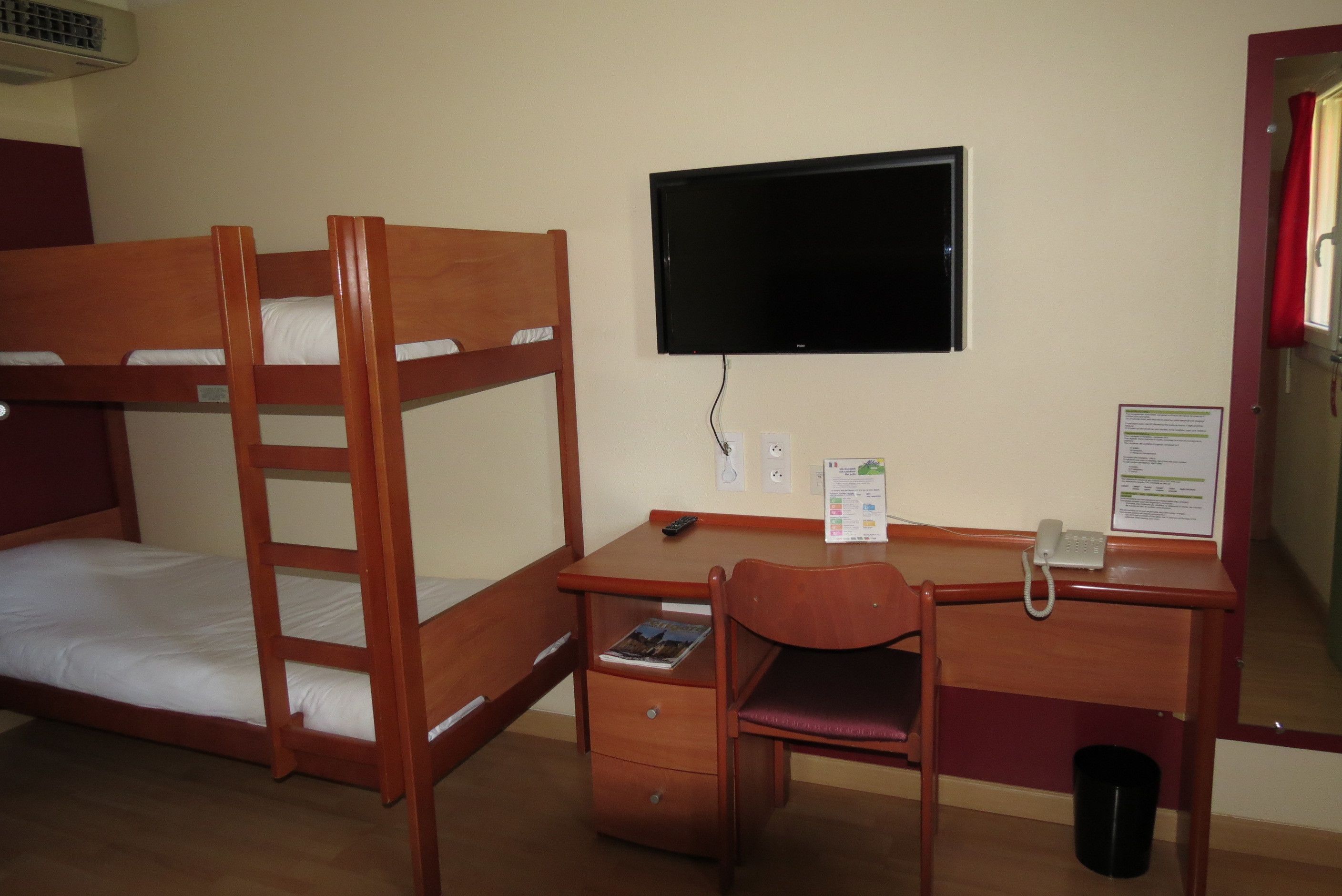 Una cama literera, un escritorio con silla, un televisor y un teléfono.