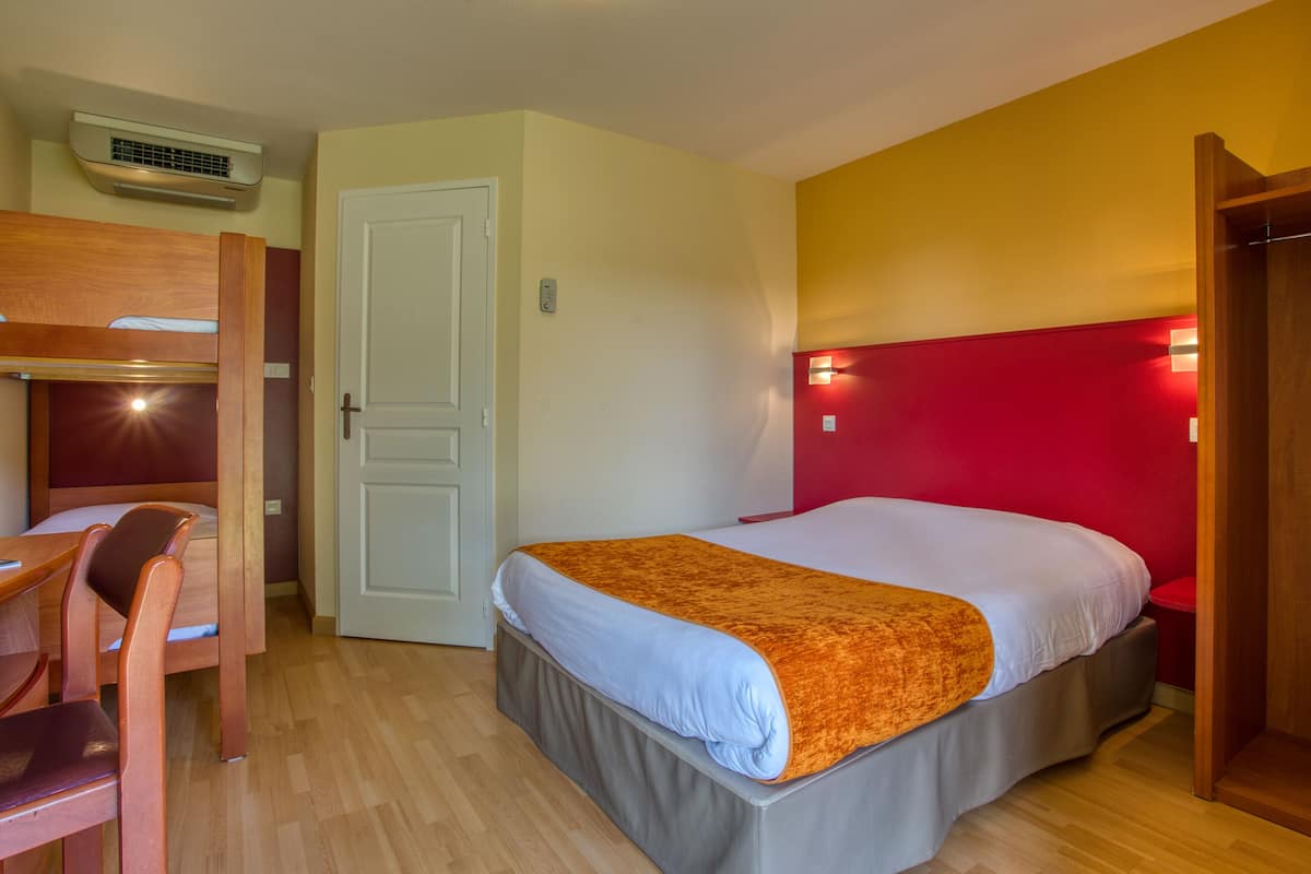 A room with a bed, a desk, and a chair.