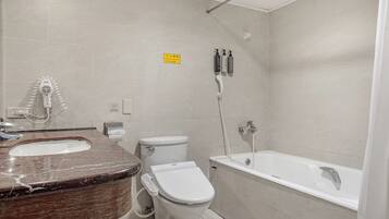 A bathroom with a toilet, bidet, and bathtub.