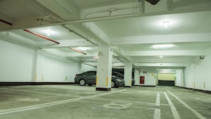 Un aparcamiento de varios niveles, con plazas de aparcamiento delimitadas y un coche estacionado en una de ellas.