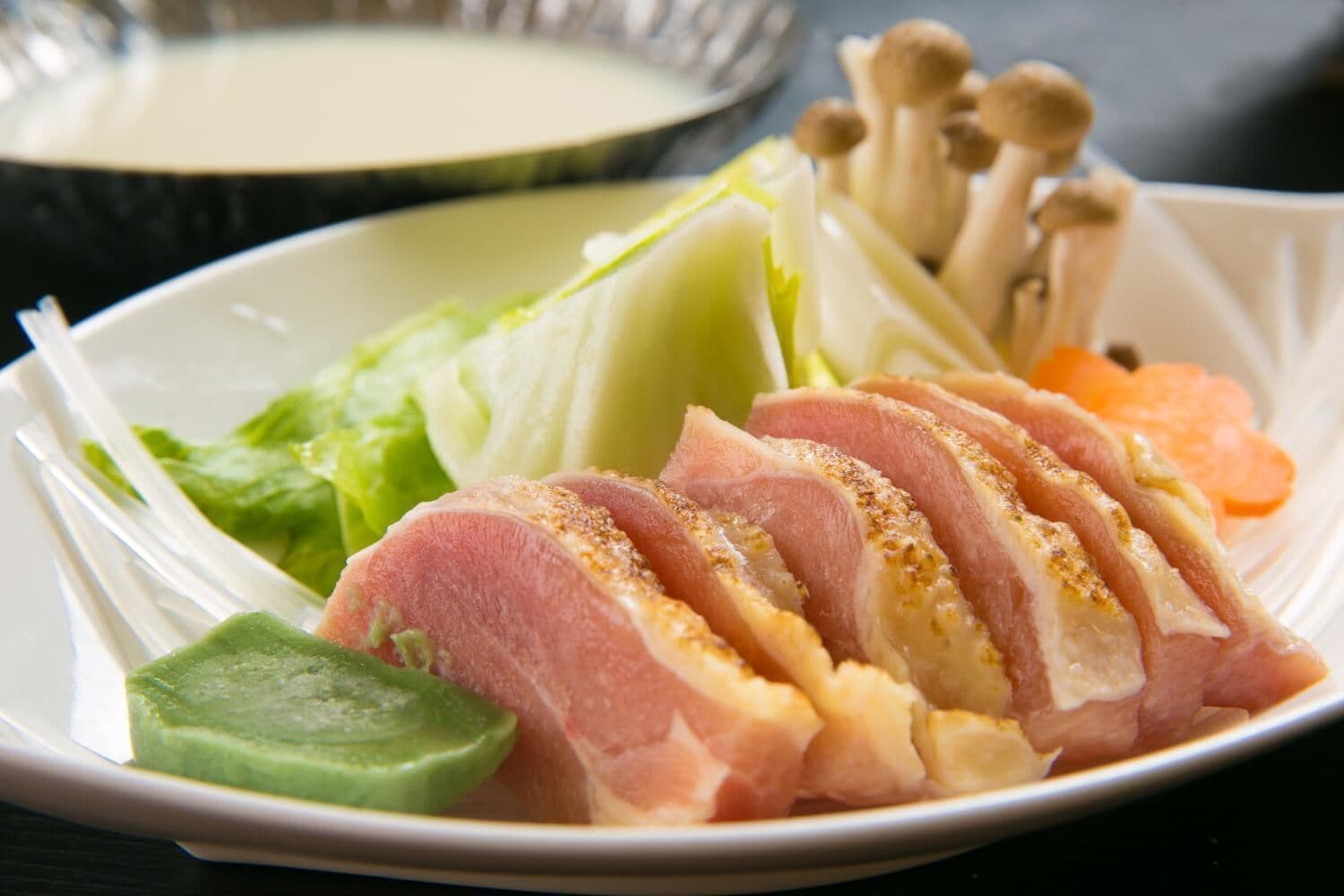 A plate with sliced meat, vegetables, and mushrooms.