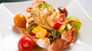 A lobster tail with vegetables on a white plate.