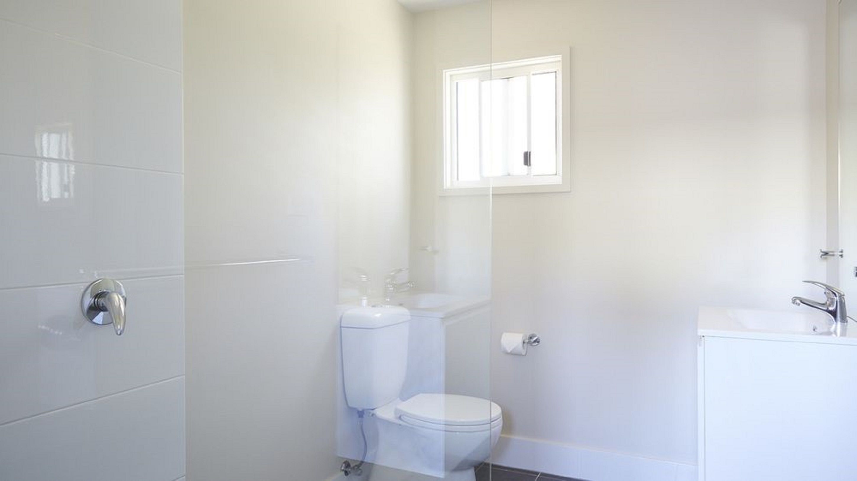 A bathroom with a toilet, sink, and shower area.