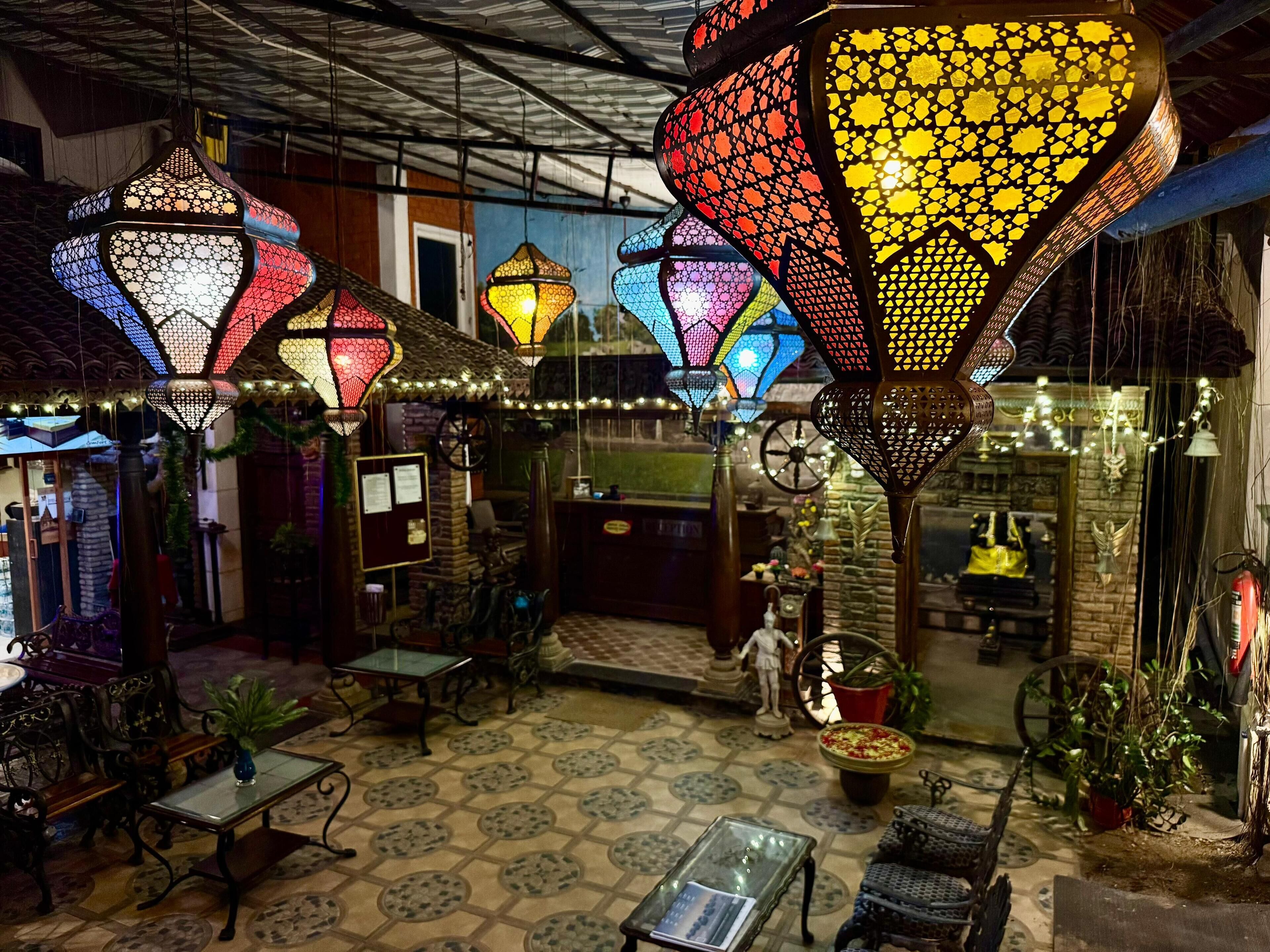 A traditional interior with hanging lanterns, a tiled floor, and a small seating area.