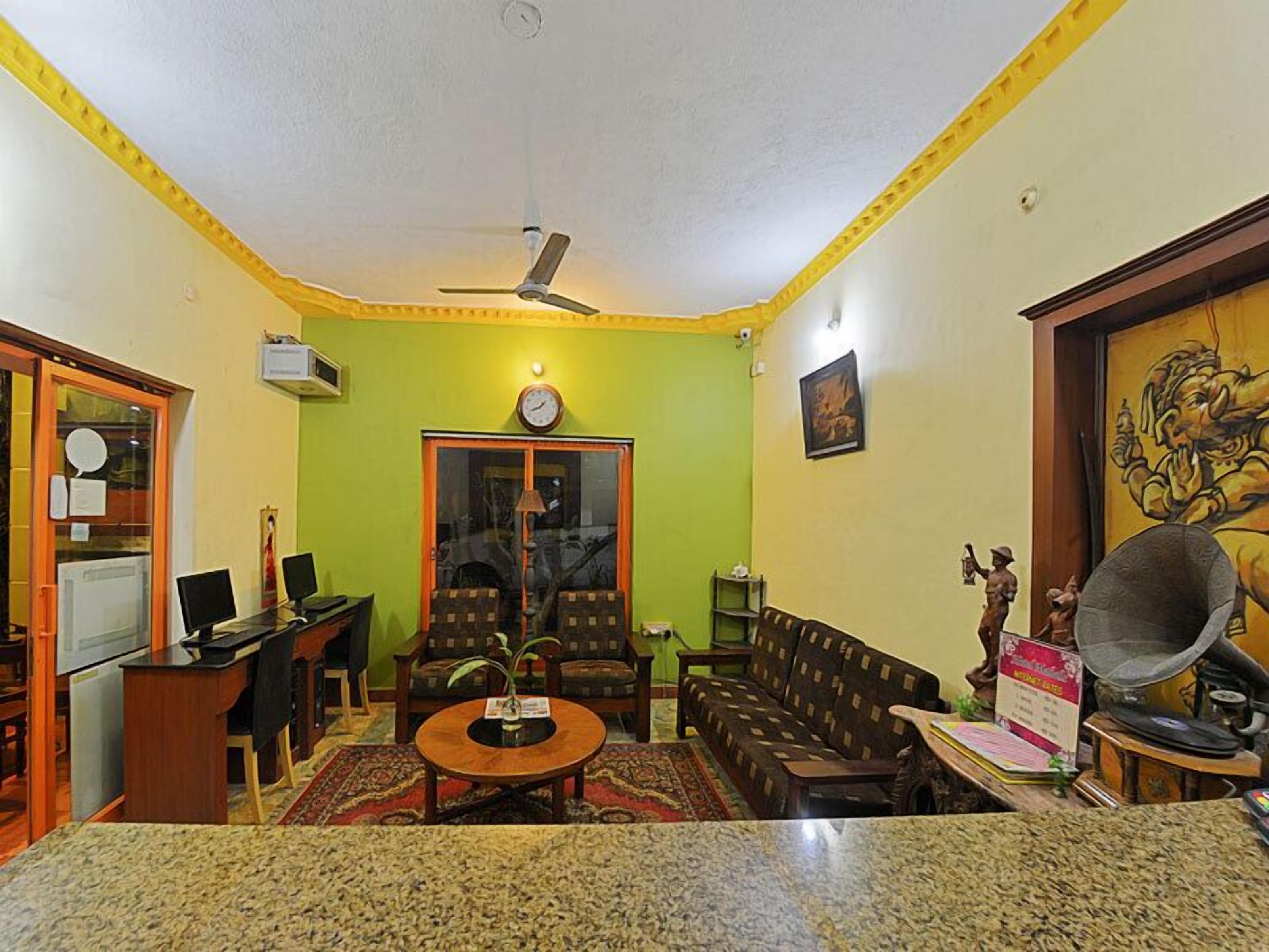 A living room with a sofa set, a coffee table, a television, and a ceiling fan.