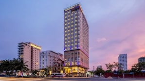 A tall hotel with multiple floors and a prominent sign at the top. - 7 Seven Sea Hotel  (Da Nang)