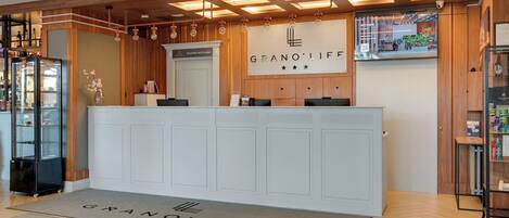 Un comptoir d’accueil avec une enseigne indiquant « GRANO’LIFE », un intérieur en bois et une vitrine.