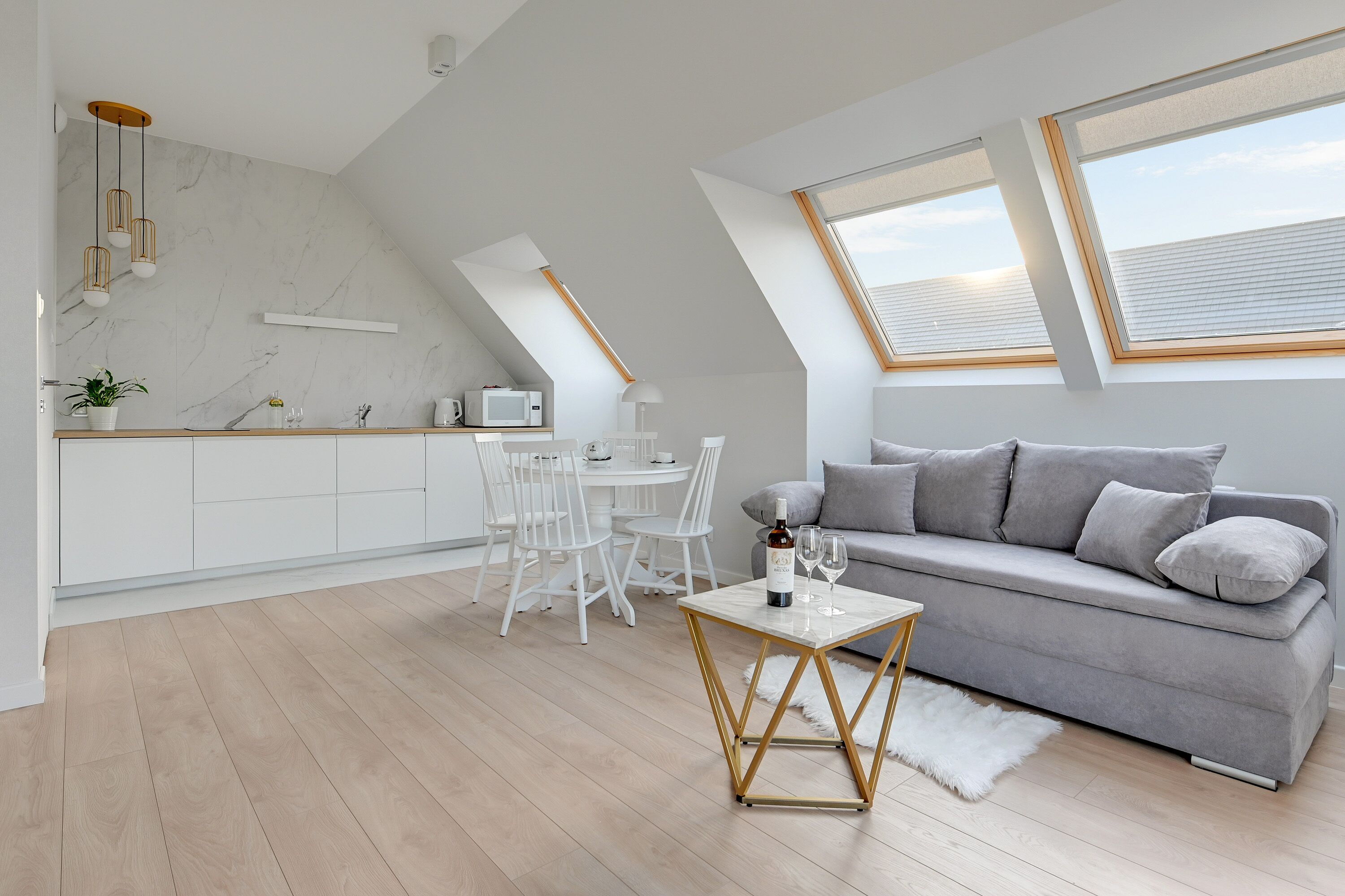 A modern loft apartment with a dining area, kitchen, and living space.