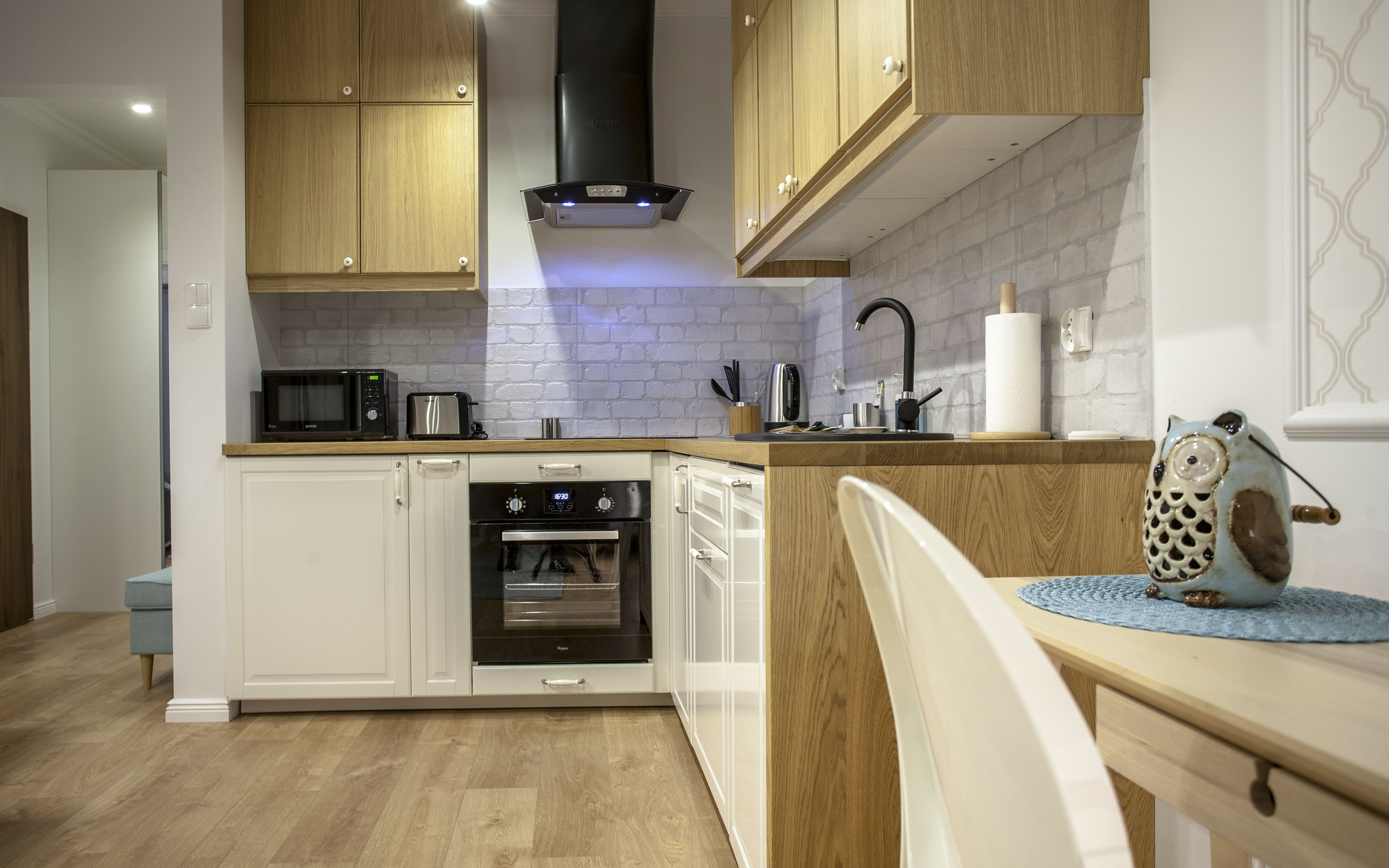 A modern kitchen with wooden cabinets, a microwave, toaster, and oven.