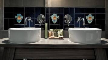 A bathroom with two sinks, a mirror, and decorative tiles.