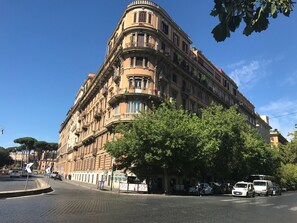 Un bâtiment historique à l’architecture classique, doté de nombreux balcons et caractérisé par un angle particulièrement marqué.