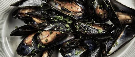 Un plato de mejillones adornados con hierbas.