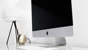 A modern desktop computer with a keyboard and mouse on a reflective surface.