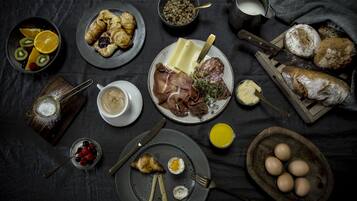 Een ontbijt met verschillende soorten eten en drinken op een donkere tafelkleed.