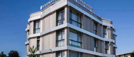A modern building with the sign "VISIONAPARTMENTS" on the top.