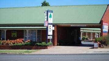 A building with a green roof, a 'Bike Friendly' sign, a 'No Vacancy' sign, and a 'Clearance 2.400mm/8ft' sign.