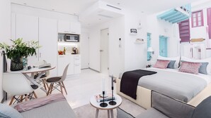 A modern hotel room with a kitchenette, a dining area, and a bedroom with a bed, bedside table, and a nightstand. - VISIONAPARTMENTS Vevey Rue des Communaux (Vevey)