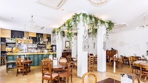 A restaurant with wooden furniture, a bar area, and green plants hanging from the ceiling. - VISIONAPARTMENTS Vevey Rue des Communaux (Vevey)