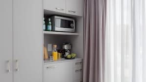 A modern kitchen with grey cabinets, a microwave, and a basket of fresh produce. - VISIONAPARTMENTS Vevey Rue des Communaux (Vevey)